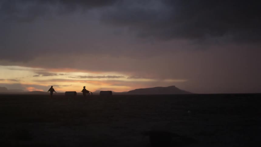 Two people run across a field as lightning flashes in the dawn sky