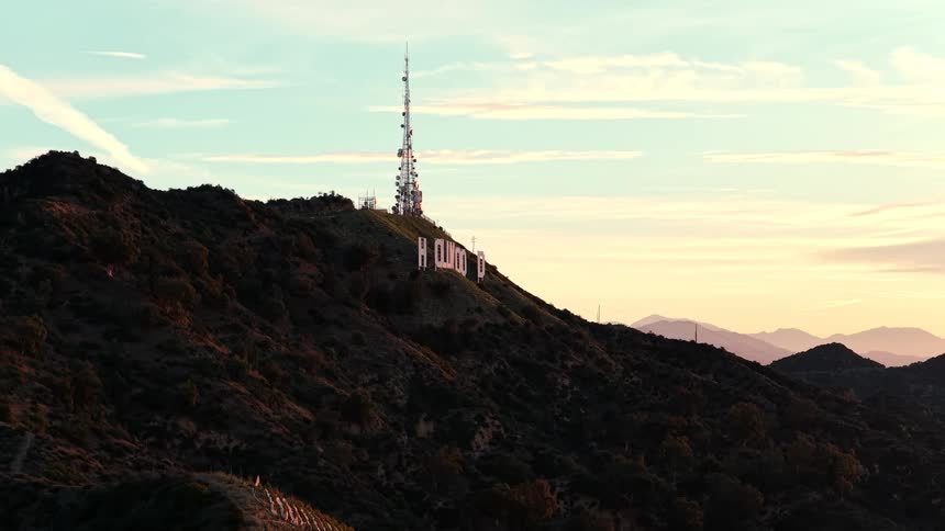 Hollywood sign prominently set against orange dusk sky