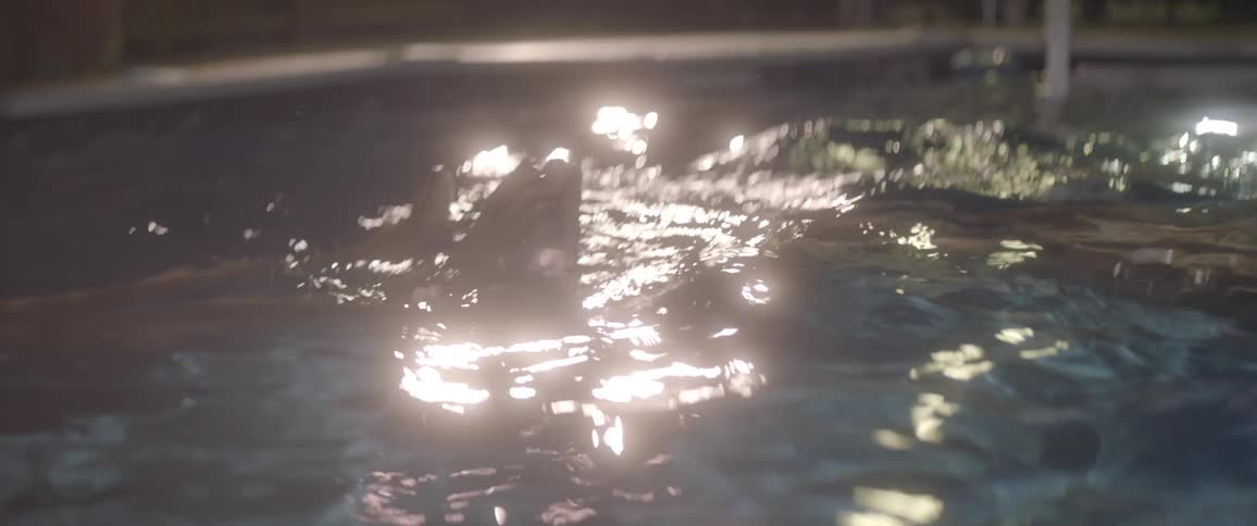 Two women play together in a backyard swimming pool