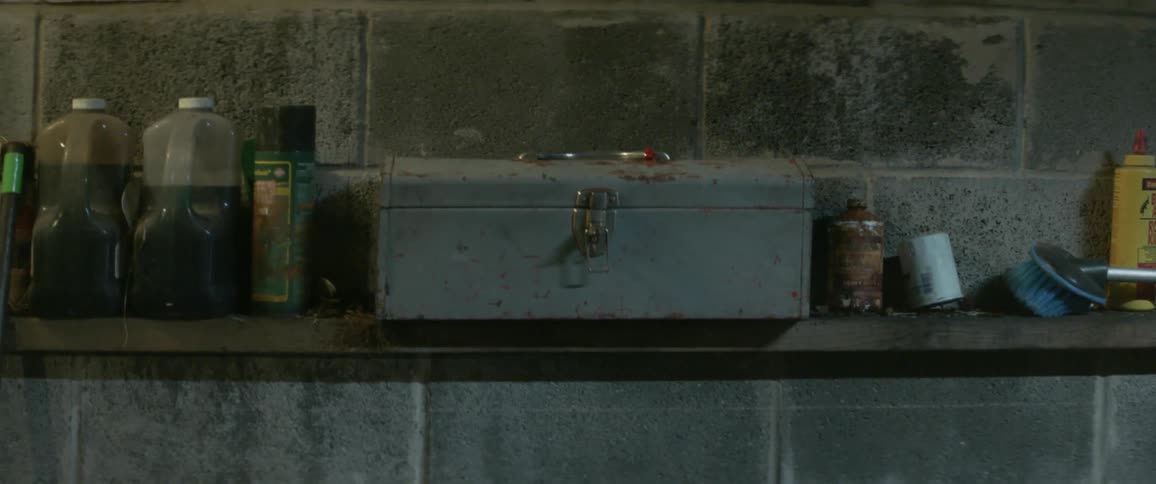 A shelf with a locked metal box and bottles of chemicals
