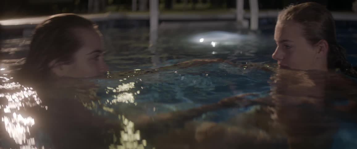Two women swim together in the pool