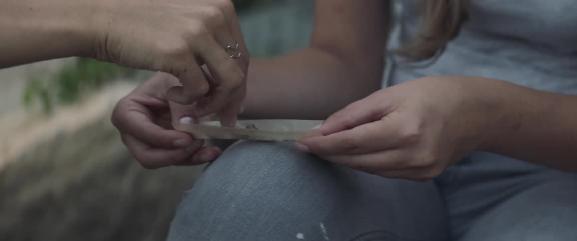 A woman is rolling a joint