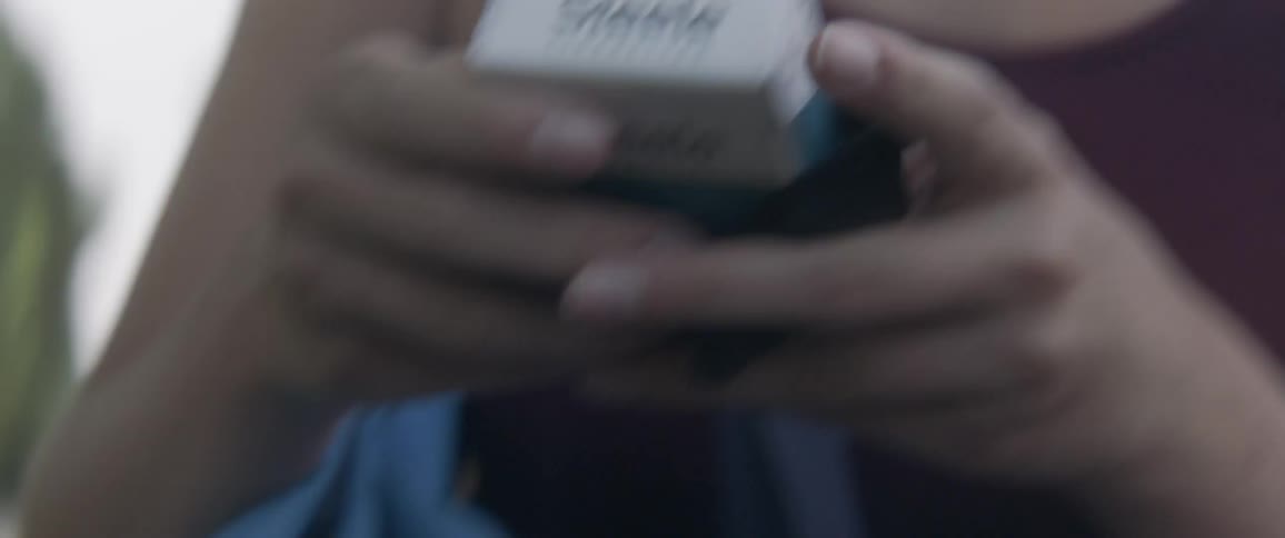 A woman pulls a pack of cigarettes out of her backpack