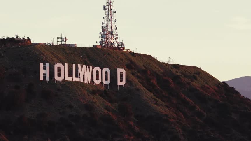 Letters spelling hollywood on a mountainside with a communications tower