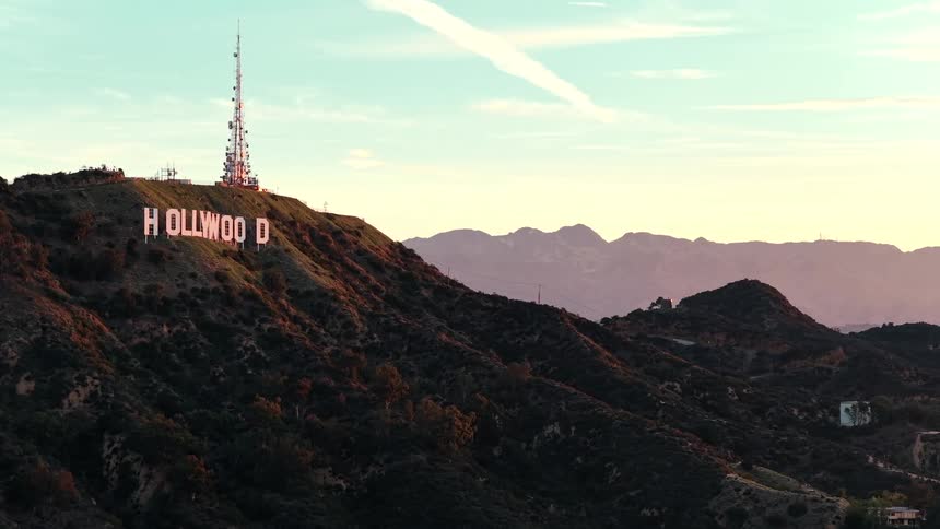 A sign and cellphone tower is high up on a mountain
