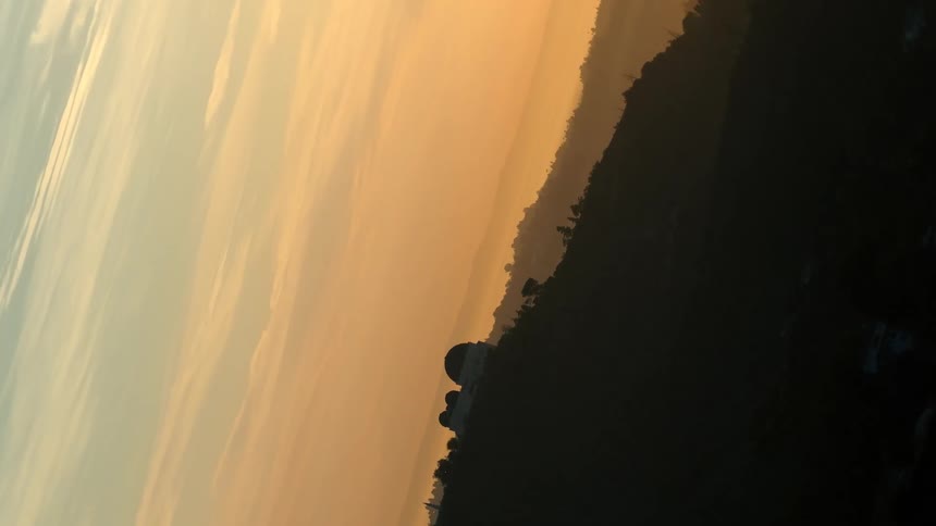 A disorienting upsidedown landscape slowly rotates over a hazy valley to reveal the iconic griffith observatory silhouetted against a beautiful golden sunset