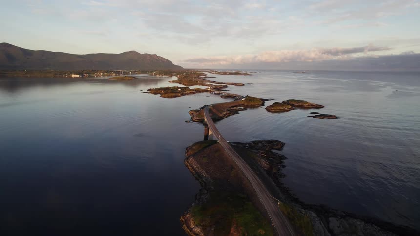 Bridge connecting islands across the water with mountains along the coast