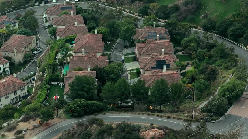 Redroofed homes with solar panels along a treelined road