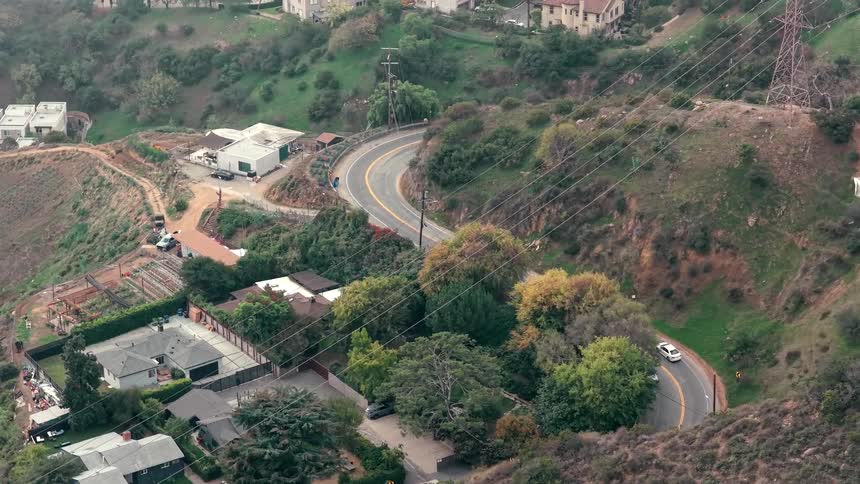 Cars travel on the winding road on the hills