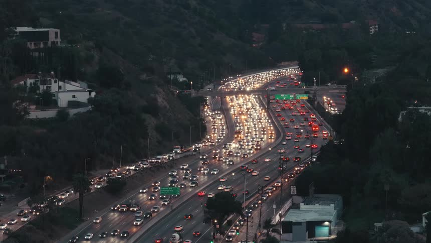 Aerial view of automobiles moving in many lanes stuck in heavy traffic on the freeway