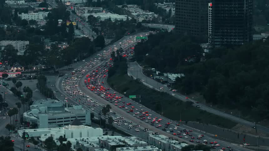Urban congestion stretching along the highway at dusk