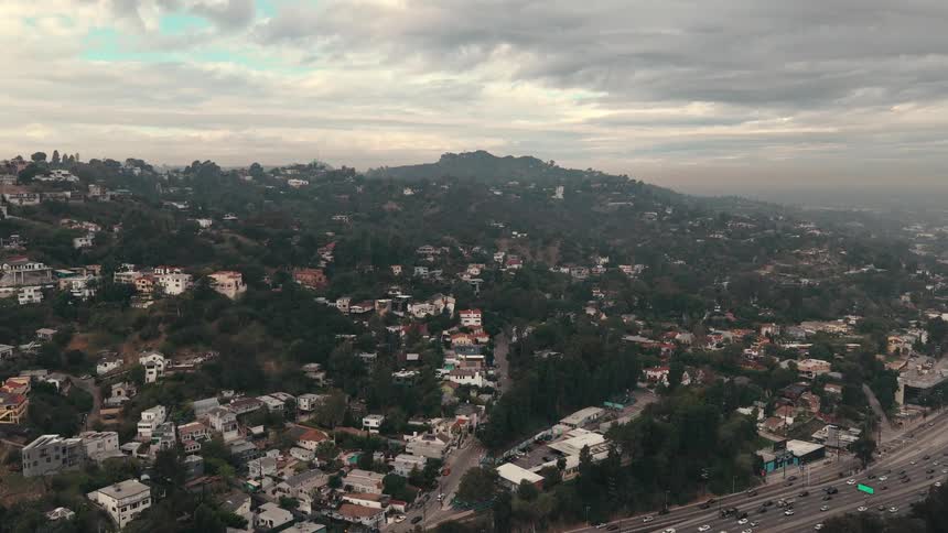 Traffic moves on a highway through a city in the mountains