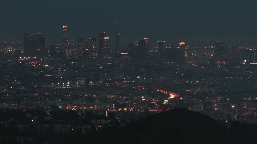 Downtown los angeles lit at night with heavy traffic on winding avenue