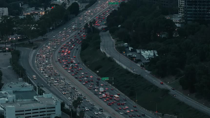 Aerial view of automobiles moving in many lanes stuck in heavy traffic on the freeway