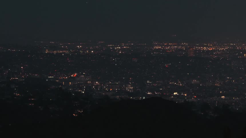 Urban lights spread across the city at night seen from an elevated viewpoint