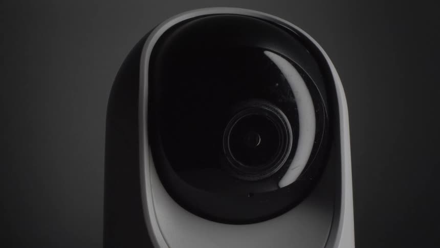 A black and white smart camera rotating in a room