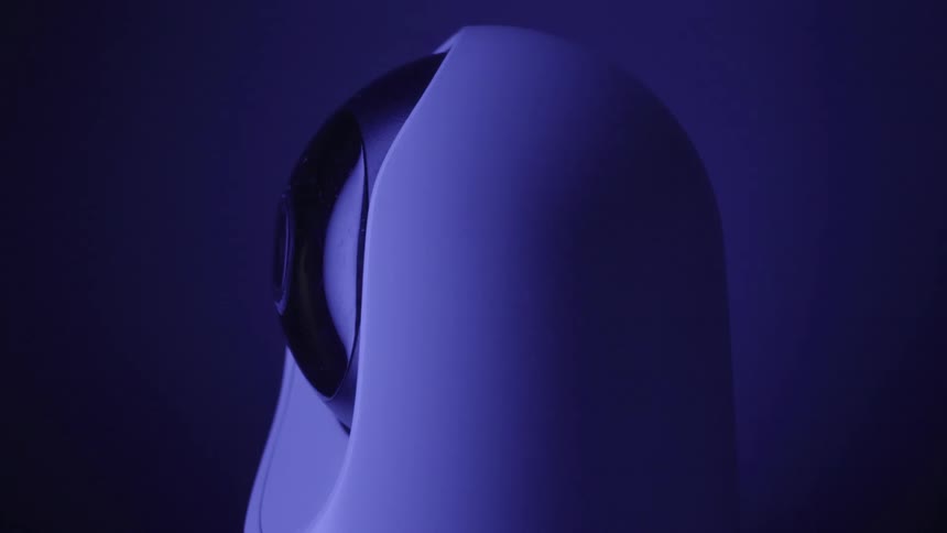 Modern security device with exposed lens under blue and purple lighting