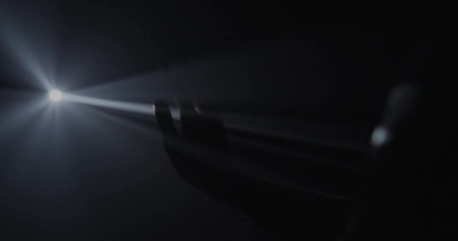 A person sticks their hand through a light projection
