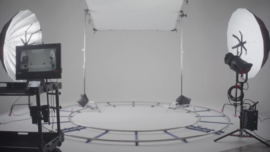 A photo studio with a camera and lighting equipment set up on the stage ready for a shoot
