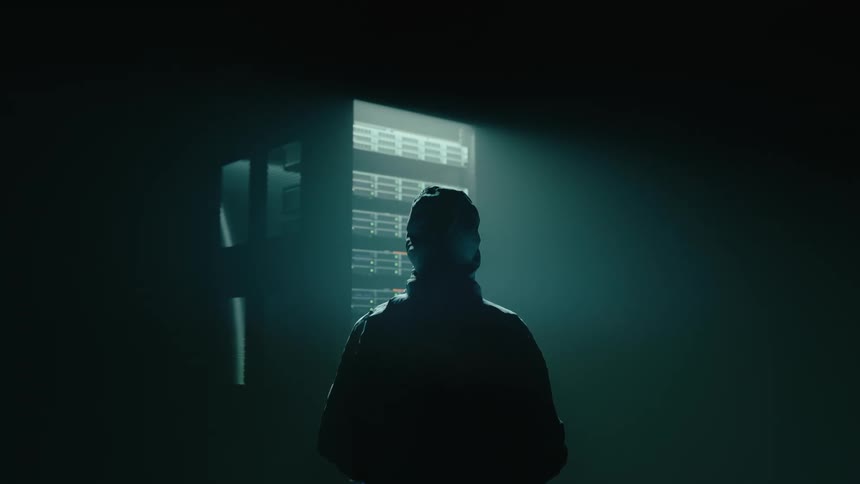 Back of a man Standing In Data Center Looking At Server Rack