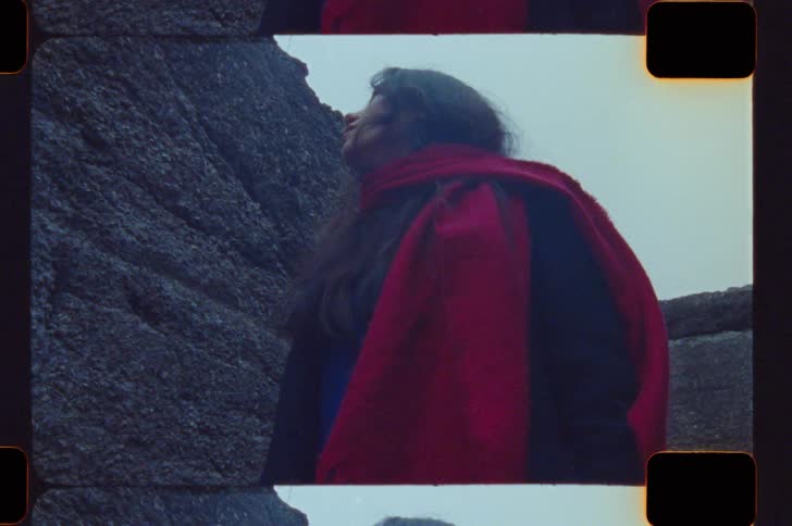 The woman is searching around the ruins