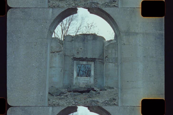 The person walks by the archway of the ruins