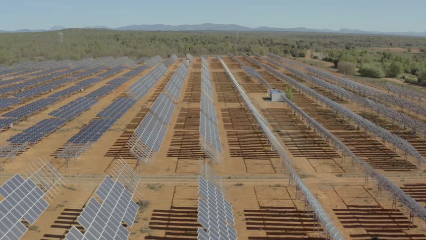 Sunlight shines on solar panels on a solar farm