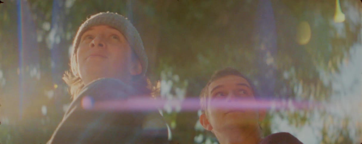The teenagers stand under the tree