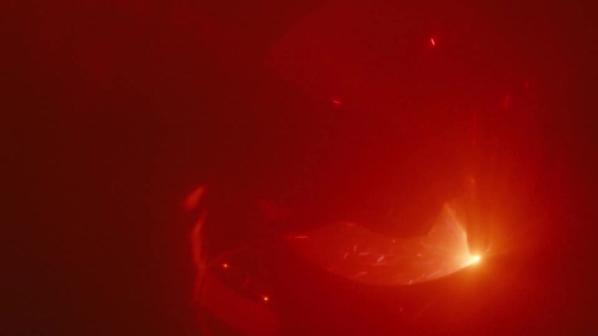 The worker is using a torch in the dark factory