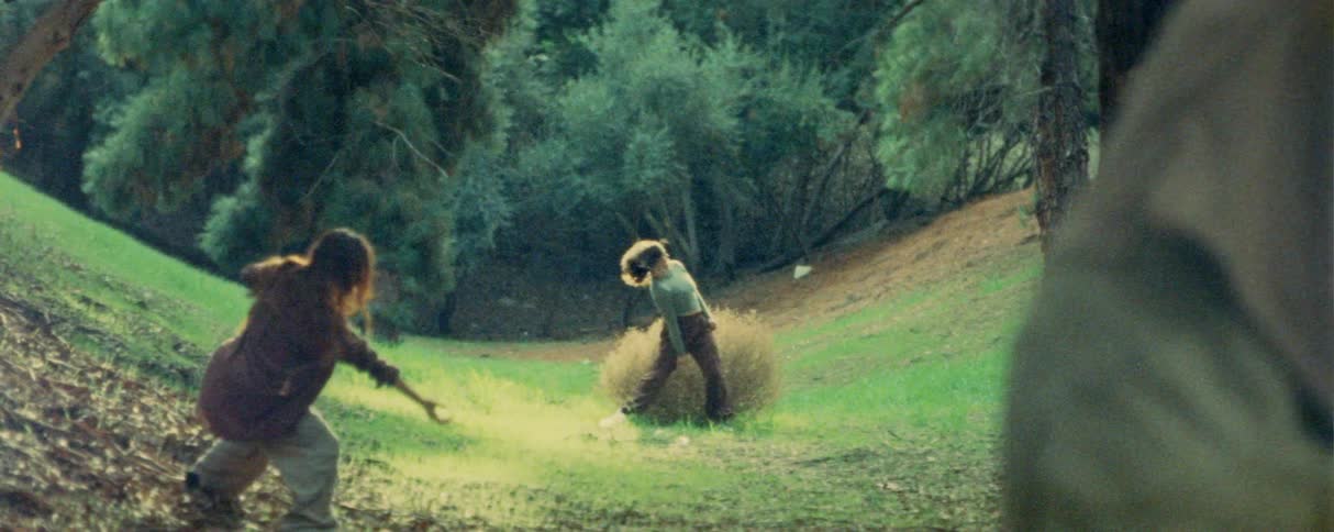 Two female and a male dancers doing contemporary dance moves on a park outdoors surrounded by trees during day time