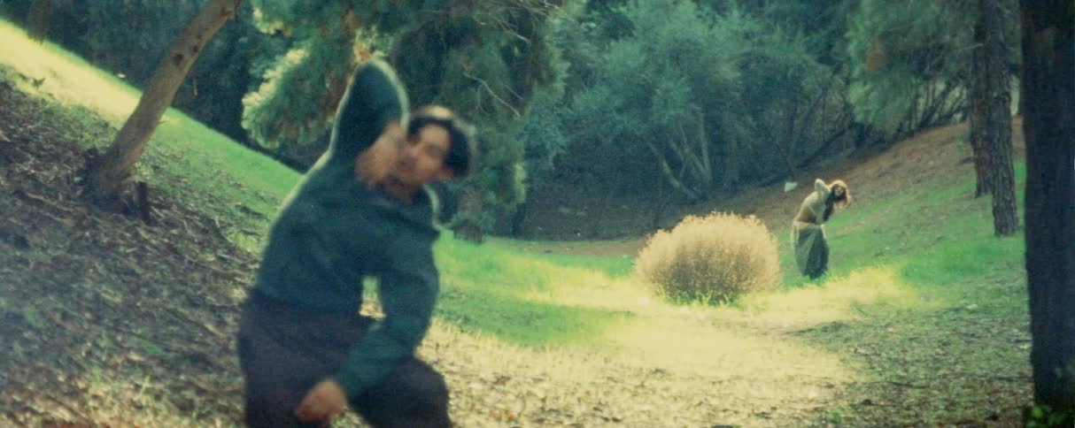 The man and woman are doing tai chi near the hill