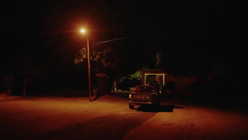 Truck parked on a road under a street light near buildings