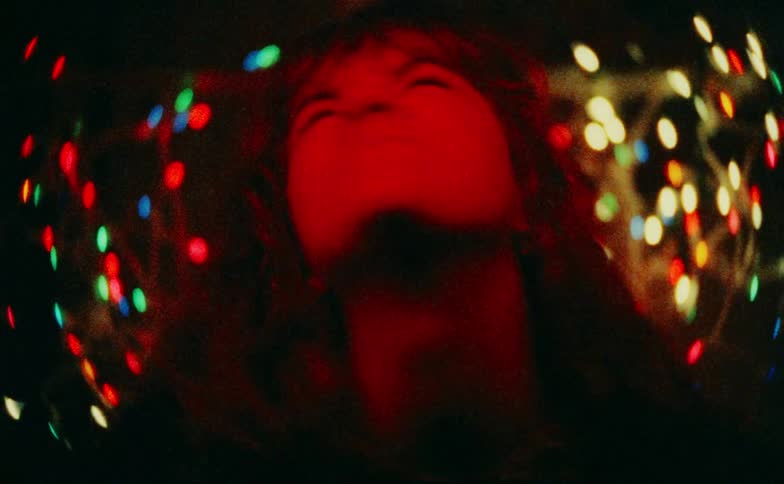 Woman in a room with colored lights making multiple expressions