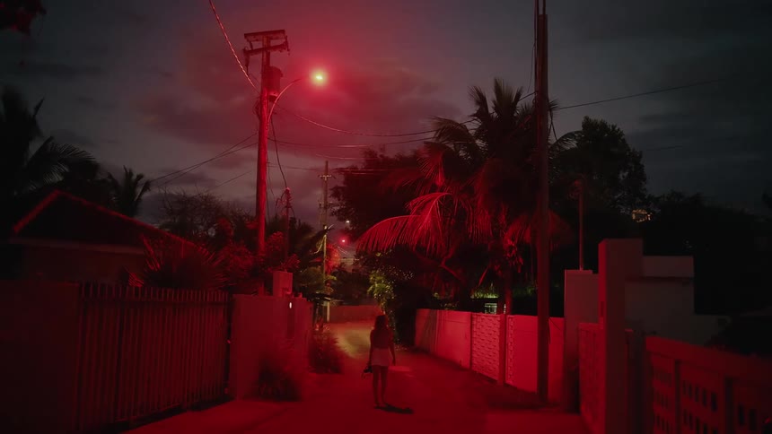 The woman walks down the alley at night