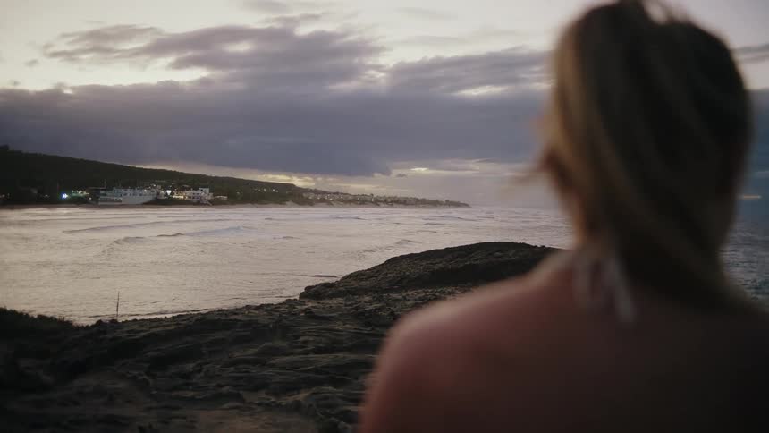 The woman is photographing the shore