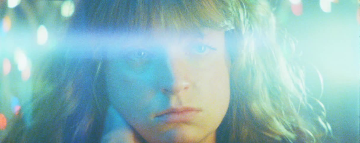 Woman with her hand on her neck in an environment of colored lights