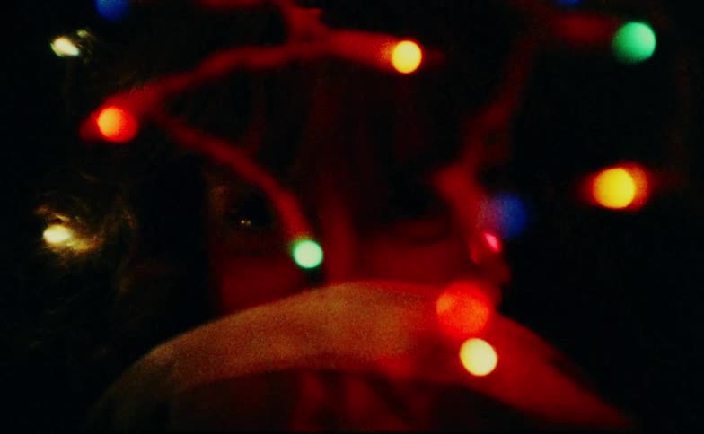 Womans face with a happy expression gazing at colored lights