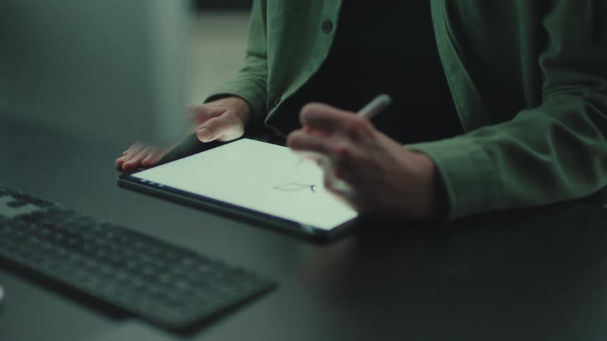 The man is drawing on his tablet