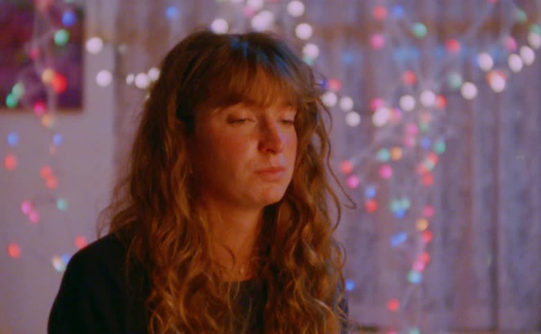 Person indoors with blurred colorful decorative lights in the background