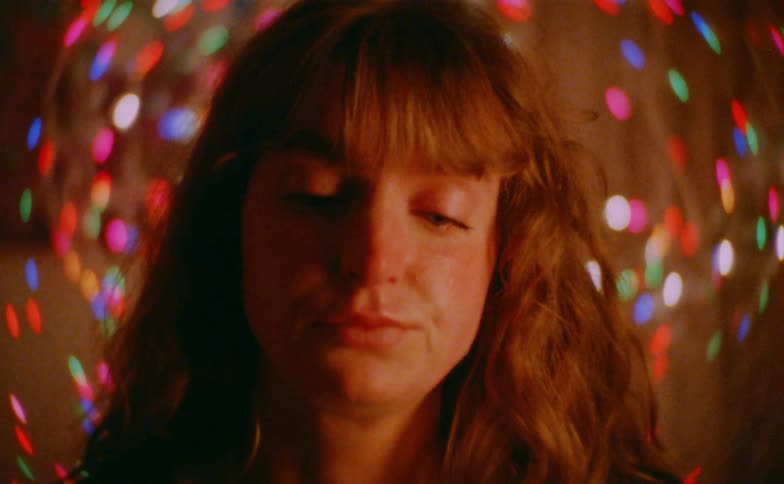 Close up portrait of a sad woman in a room filled with decorative disco lights
