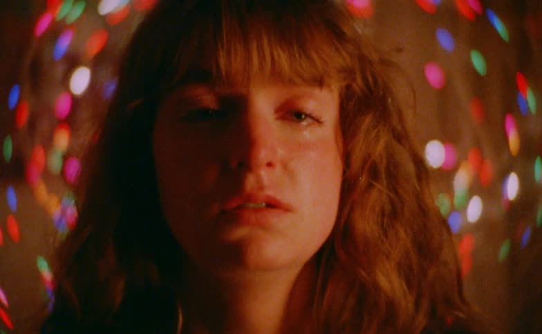 Teenager girl crying in a room with colored lights indoors