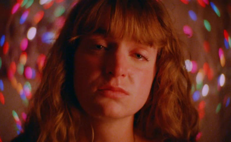 Close up portrait of a sad woman in a room decorated with disco lights