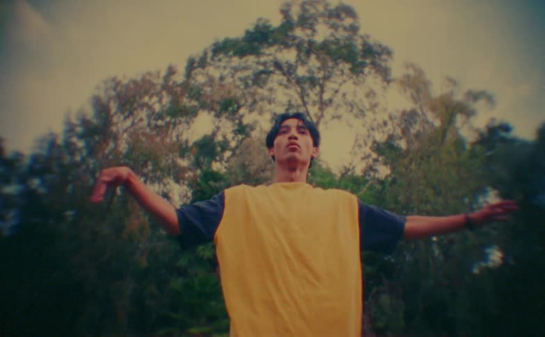 Man dancing and moving his arms in an outdoor setting