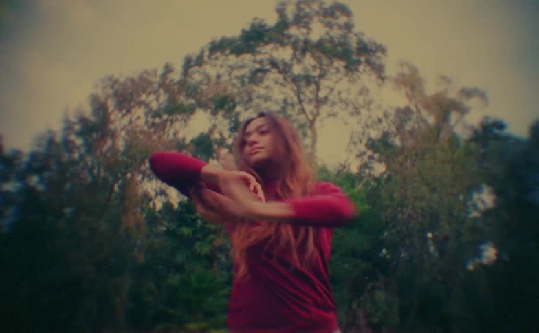 A young female dancer dancing outdoors during daytime