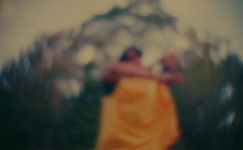 Teenager boy performing dance moves outdoors with trees on the background during day time