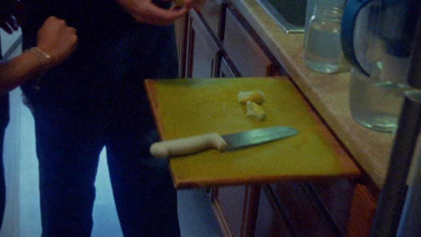 A young couple making a citrus flavoured drink together in the kitchen during daytime