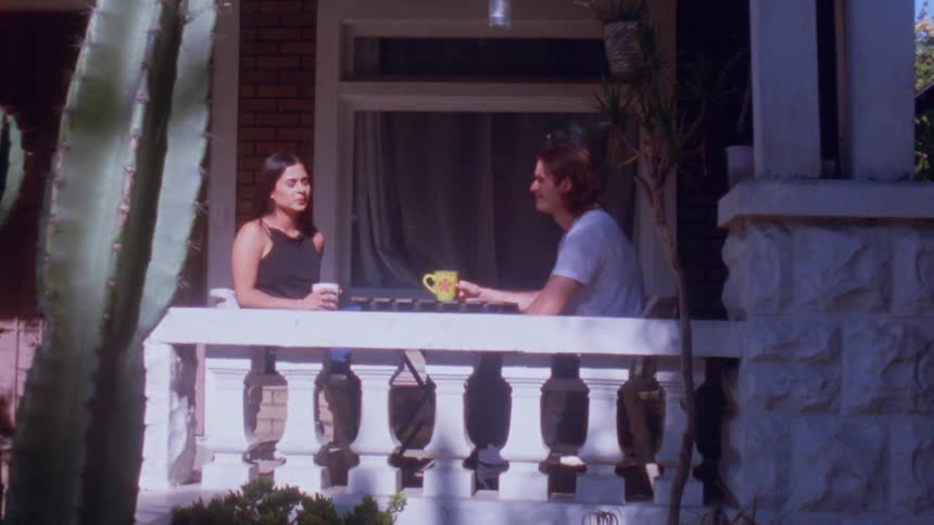 The couple have coffee on the porch