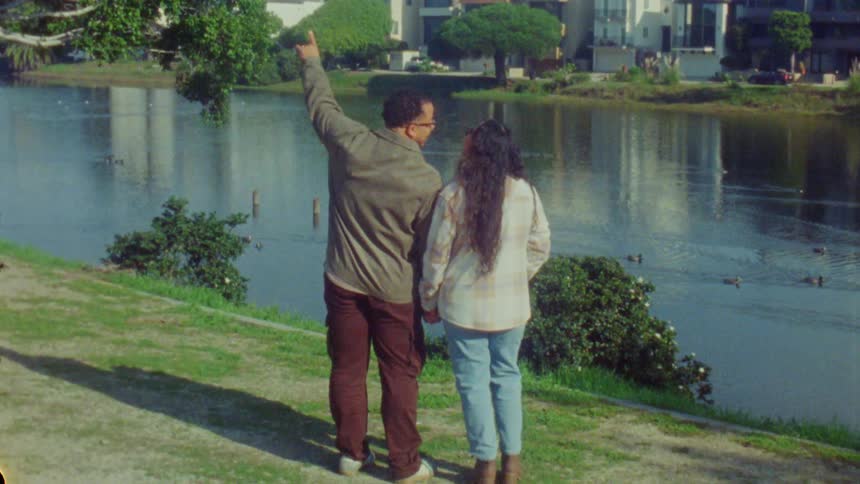 A man and woman looking at a lake and talking