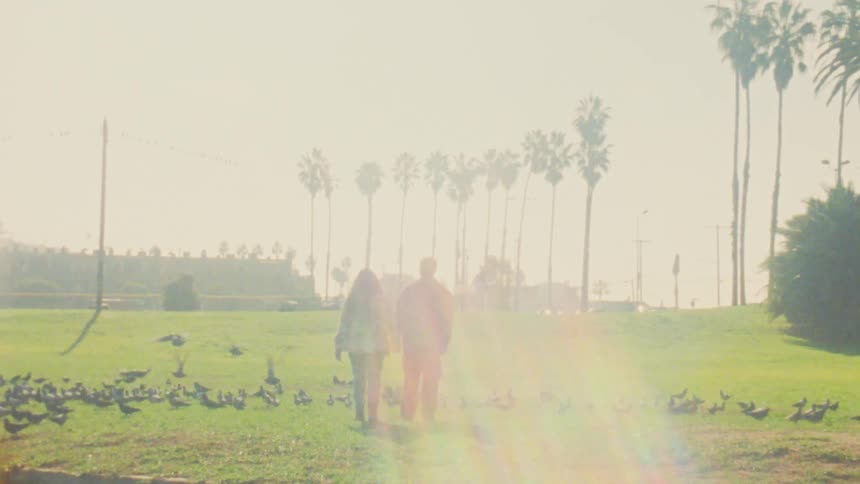 A man and woman walking while holding hands