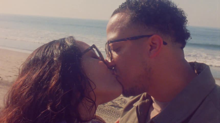 A man and woman kissing at the beach